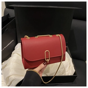 Détail du sac bandoulière rouge vintage avec fermoir en U doré sur doublure satin