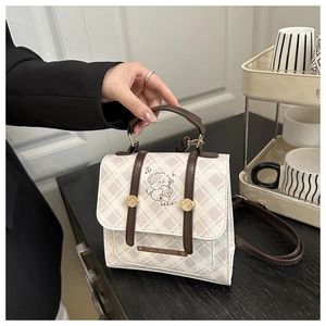Detail of checkered square handbag featuring a cute sheep illustration and top handle