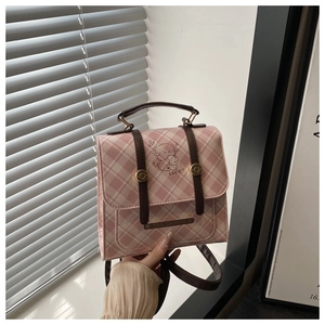 Detail of pink plaid bag showing a cute cartoon dog illustration and textured strap handle