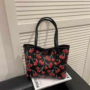 Black tote bag with red cherry print and golden fashion lettering detail
