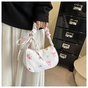 Detail of white floral shoulder bag with pink roses and ruffled cloud handle straps