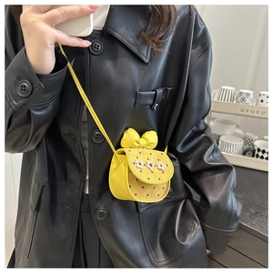 Détail du sac à bandoulière jaune vif avec grand nœud et fleurs blanches décoratives