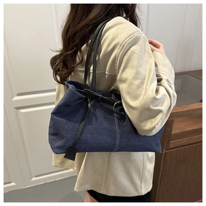Dettaglio borsa tote grande in denim con cuciture a contrasto e manici in pelle