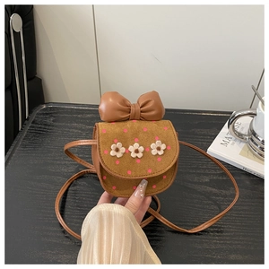 Détail d'un mini sac bandoulière marron avec pois roses, fleurs 3D et un grand nœud