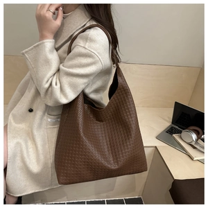 Détail d'un grand sac cabas en cuir tressé marron avec une texture Intrecciato de qualité