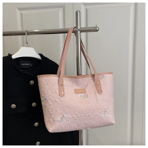 Detail of pink tote bag featuring 3D embossed pattern and colorful sequin bow embroidery