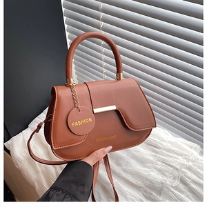 Close-up of brown leather saddle bag with gold metal hardware and brand engraving