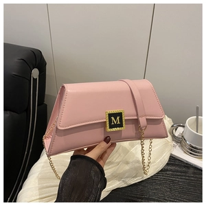 Close-up of pink leather pillow bag featuring a gold square buckle with M letter detail