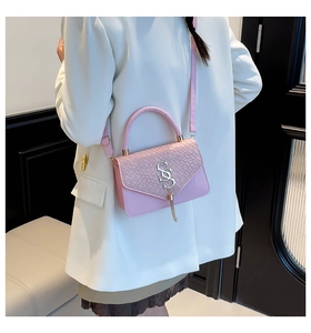 Détail de sac rose avec texture crocodile et fermoir à pompon argenté élégant