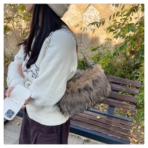 Détail du sac à bandoulière en fausse fourrure avec chaîne argentée et texture dégradée