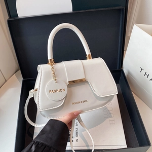 Elegant white leather saddle handbag with gold hardware and top handle in a gift box