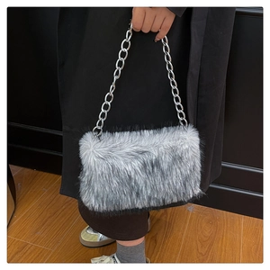 Détail d'un sac en fausse fourrure grise avec une bandoulière en grosse chaîne argentée