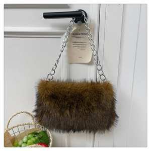 Détail de la texture d'un sac bandoulière en fausse fourrure marron avec chaîne