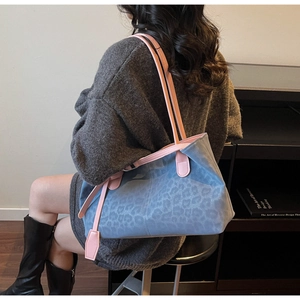 On-body view of large blue leopard print tote bag with contrasting pink leather straps
