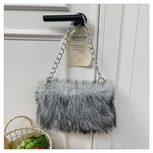 Détail du sac en fausse fourrure grise avec une épaisse bandoulière en chaîne argentée