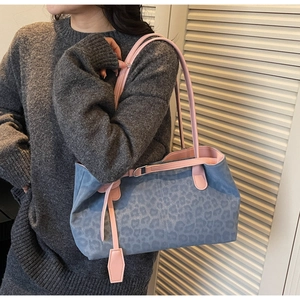 Detail of grey leopard print tote bag with contrasting pink shoulder straps and trim