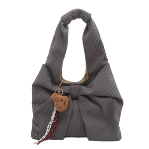 Grey corduroy tote bag with large bow and brown teddy bear pendant on white background
