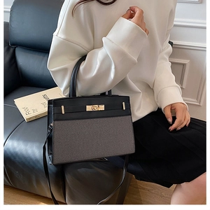 Detail of color-block canvas handbag with leather flap and golden twist-lock closure