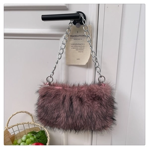 Détail de la texture en fausse fourrure rose et chaîne en métal argenté du sac