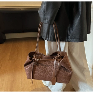 Detail of leopard print tote bag featuring matte suede texture and retro metal buckles