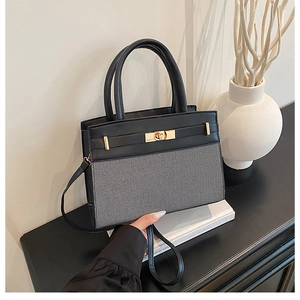 Detail of color-block crossbody bag with gold twist lock and elegant office accessories