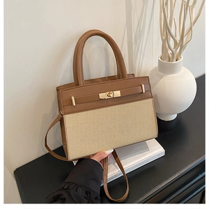 Detail of contrast stitch leather and woven texture with gold twist lock closure