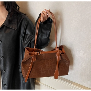 Detail of leopard print tote bag with brown leather straps and silver buckle finish