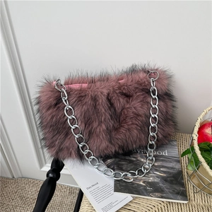 Sac à épaule en fausse fourrure rose poudré avec grosse chaîne argentée sur chaise