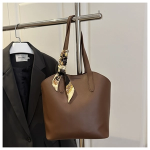 Detail of dark brown tote bag handle with stylish geometric pattern silk scarf wrap