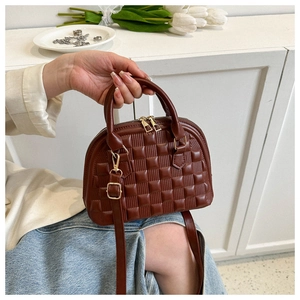 Detailed macro view of the brown textured shell bag with golden hardware and PU leather strap