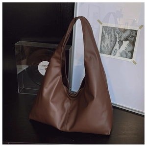 Detail of dark brown faux leather tote with soft texture and vertical stitching detail