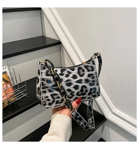 Macro shot of glossy leopard print texture and black acrylic chain on shoulder bag