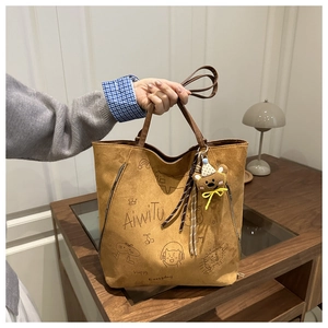 Brown frosted tote bag showing detailed printed cartoon pattern and cute bear keychain