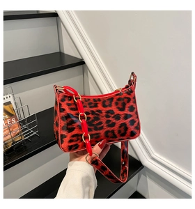 Detail of red and black leopard print underarm bag with stylish acrylic chain strap