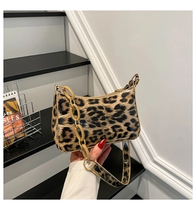 Detail of leopard print underarm bag with glossy texture and thick acrylic chain