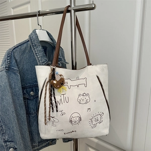 White canvas tote bag with brown leather straps and cute cartoon illustrations