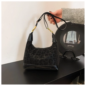 Detail of black leopard print suede hobo bag featuring letter logo and gold hardware