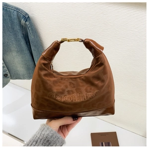 Detail of vintage brown hobo bag with leopard embossing and gold buckle hardware