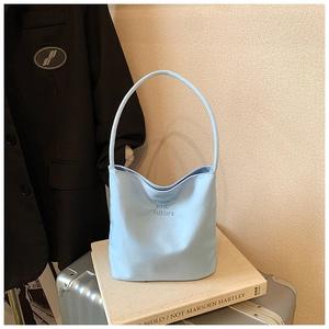 Detail of light blue bucket bag featuring embossed hope and future text on smooth leather