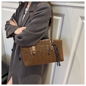 Détail du sac cabas léopard avec texte mode et pendentif en forme de raquette
