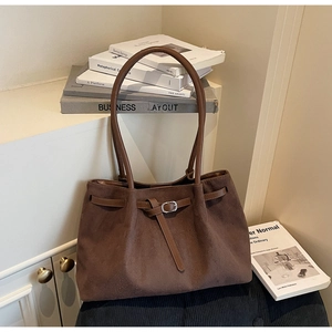 Macro shot of dark brown suede tote bag with silver buckle strap and soft vintage texture