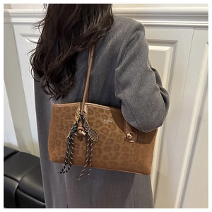 Détail du sac cabas léopard marron avec cordon tressé et pendentif raquette de tennis