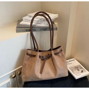 Detailed shot of khaki suede tote bag with brown leather straps and metal buckle accent