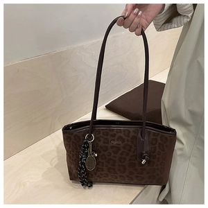 Détail d'un sac cabas léopard avec texte FASHION et pendentif raquette de tennis doré