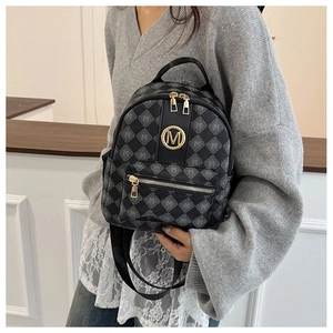 Detailansicht eines dunkelgrauen Mini-Rucksacks mit Monogramm-Muster und goldenem Emblem