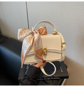 Dettaglio borsa con patta in pelle PU bianca con sciarpa di seta arancione e chiusura d'oro