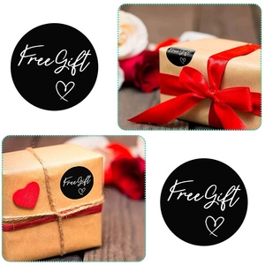 Gros plan d'autocollants noirs Free Gift avec cœur sur des boîtes cadeaux en kraft