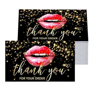 Close-up of black thank you cards featuring red lips and gold bokeh dots for business orders