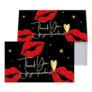 Macro shot of black thank you cards featuring red lip prints and gold foil lettering