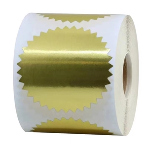 Close-up of golden serrated gear seal stickers on a roll with metallic finish